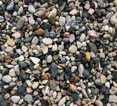 Dağlarda farklı renklerde küçük çakıl taşlarının deseni ve dokusu, yumuşak ışıklandırmalı bir arkaplan için doku