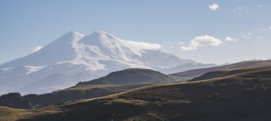 Elbrus Dağı 'nın akşam manzarası, kar ve buzullarla kaplı iki tepeden, bulutsuz sonbahar havasında.