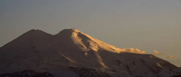 日没の照明で雪と氷河とエルブラス山の山の風景のパノラマ 曇りの日没の空 — ストック写真