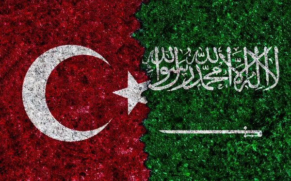 Turkey and Saudi Arabia painted flags on a wall with grunge texture. Turkey and Saudi Arabia conflict. Turkey vs Saudi Arabia