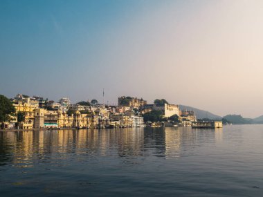 Udaipur, Rajasthan, Hindistan - 4 Aralık 2022: Pikhola gölü ve Hanuman ghat 'tan şehir sarayı manzarası