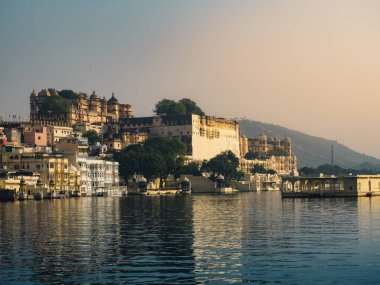 Udaipur, Rajasthan, Hindistan - 4 Aralık 2022: Hanuman ghat 'tan kısa menzilli Pichola gölü ve şehir sarayı manzarası