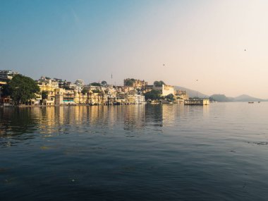 Udaipur, Rajasthan, Hindistan - 4 Aralık 2022: Hanuman ghat 'taki Pichola Gölü ve şehir sarayının uzun menzilli manzarası