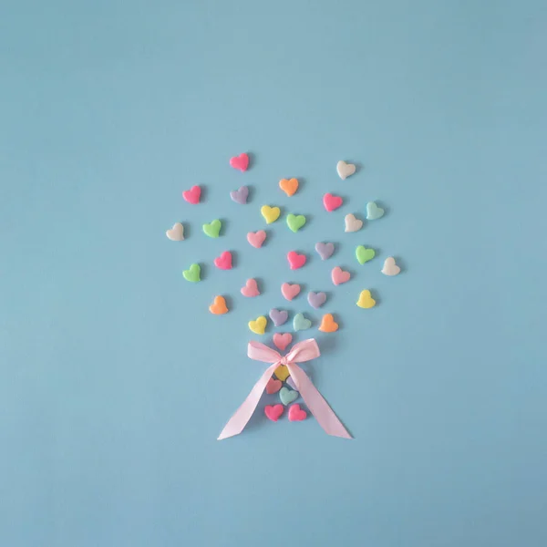 Creative concept with pastel, pink, blue, yellow, green and other colour hearts. Love flat lay. Minimal valentines day concept.
