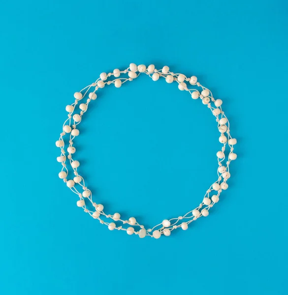 Güzel yuvarlak beyaz inci çerçeveler. Mavi arkaplanda beyaz daire düz konsept..