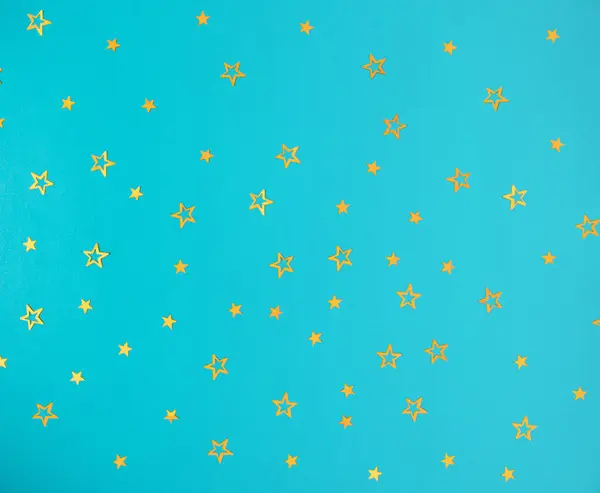 Parlak mavi arka planda altın yıldızların deseni. Düz konsept.