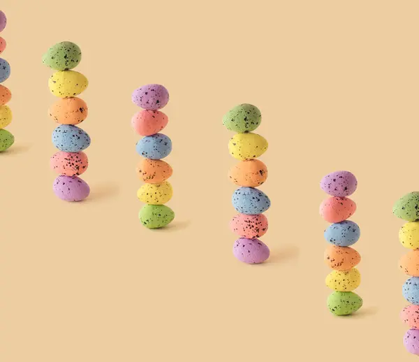 Pastel Paskalya yumurtaları bej arka planda. Pembe, mor, mavi, turuncu, sarı ve yeşil pastel renkli yumurtalar. Düz konsept.