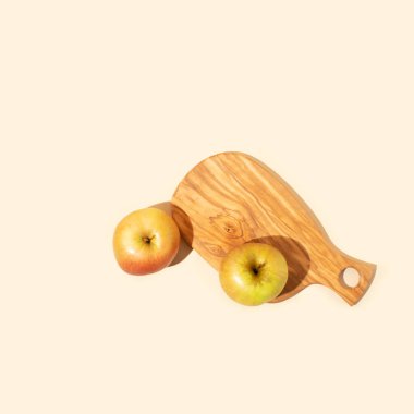 Açık bej arka planda taze elmalı ahşap bir tabak. Düz yatıyordu.