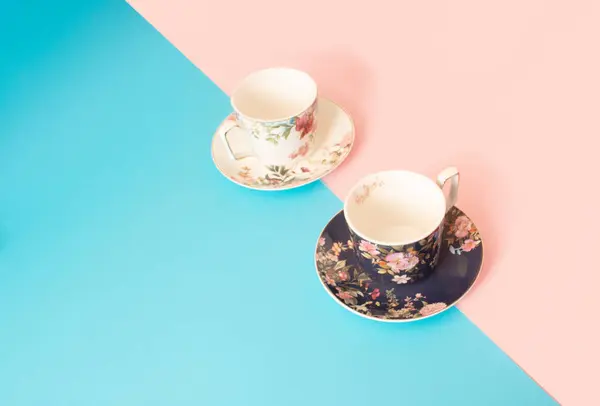 Mavi ve pembe arka planda izole edilmiş pembe ve mavi kahve ya da çay fincanları.