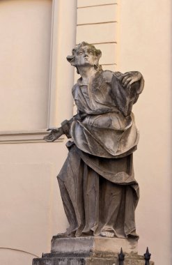 Klasik bir arka planda dramatik duruşu olan tarihi bir heykelin antik taş heykeli. Barok sanatının ve kültürel mirasının mükemmel bir temsili.