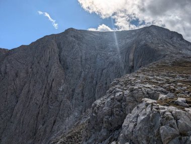 Açık mavi gökyüzünün altında kayalık bir dağın güzel manzarası.