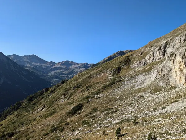 Dağları ve mavi gökyüzü olan güzel bir manzara.