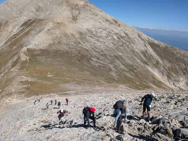 Dolomite 'larla dağın tepesinde yürüyüş yapan insanlar.