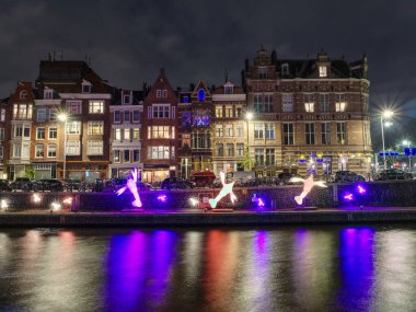 Işık festivali gecesi, Amsterdam, Hollanda 'da kanal üzerindeki sanatsal unsurlar
