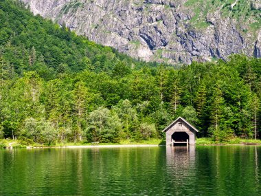 Konigssee Gölü 'nde kayıkhane ve orman yansımaları. Almanya, Bavyera 'da Güzel Manzara