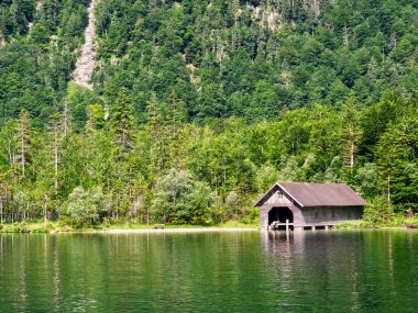 Konigssee Gölü 'nde kayıkhane ve orman yansımaları. Almanya, Bavyera 'da Güzel Manzara