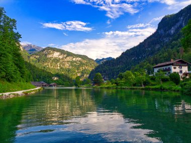 Konigssee Gölü 'nün genel görünümü. Bulutlu gökyüzü gölün içinde sakin suları yansıtıyor. Bavyera, Almanya 