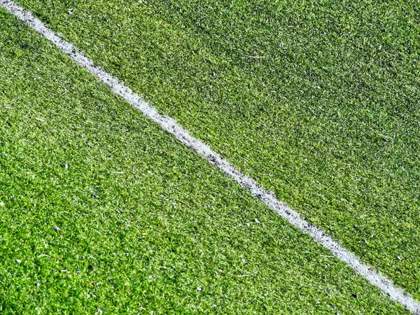 Futbol sahasındaki yeşil çimlerde çapraz beyaz çizgi. Yüksek kalite fotoğraf