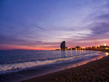 Barceloneta sahili, gün batımı renklerinde deniz manzarası ve bulutlu çarpıcı bir gökyüzü.. 