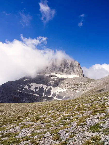 Mountain peak in blue sky and white clouds. Stefani peak also known as The Throne of Zeus, Olympus mountain, Greece