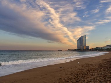 Barceloneta sahili, gün batımı renklerinde deniz manzarası ve bulutlu çarpıcı bir gökyüzü.. 