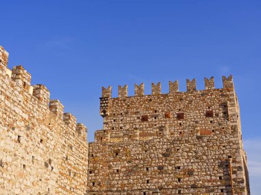 Fortified castle wall made of stone under blue sky. High quality photo clipart