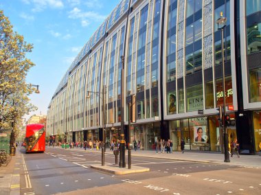 Londra, Birleşik Krallık - 28 Mart 2019: Londra caddesinde ikonik kırmızı çift katlı otobüsü olan cam önlü perakende bina