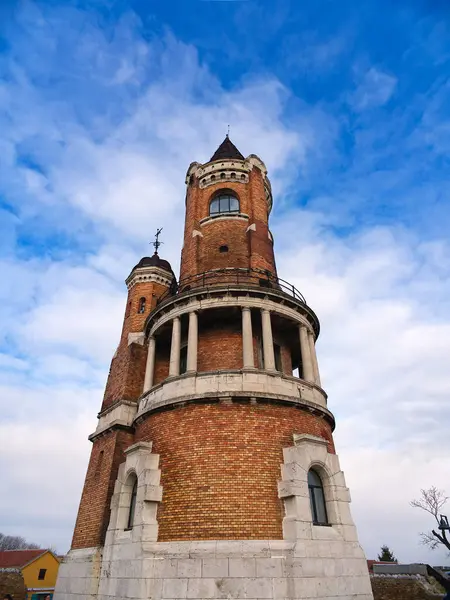 Yuvarlak balkonlu Gardos tuğla kulesi ve parçalı bulutlu mavi gökyüzünün altında ikiz kuleler. Zemun, Belgrad, Sırbistan