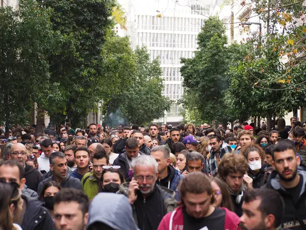 Atina, Yunanistan - 28 Şubat 2025: Ağaçlık kentsel caddede, bazıları maske takmış büyük bir kalabalık toplandı. Tempi tren kazasını protesto etmek