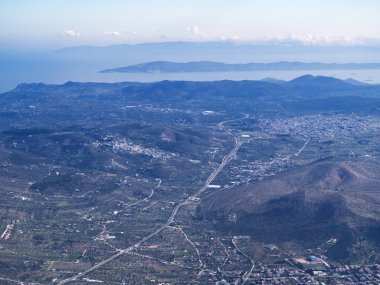 Dağlar ve denizle çevrili bir kıyı kentinin panoramik hava görüntüsü. Mezogeia, Attiki, Yunanistan