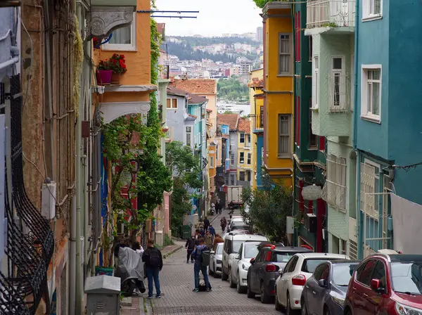 İstanbul, Türkiye 'de renkli binaların ve park halindeki arabaların bulunduğu dar, tepelik cadde