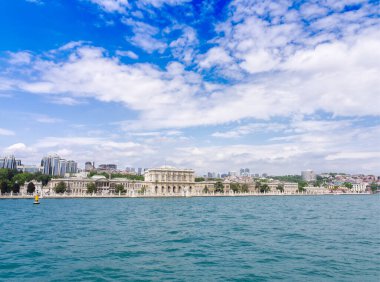 Dolmabahce Sarayı ve İstanbul şehir manzarası mavi gökyüzünün altındaki Boğaz 'ın turkuaz sularından