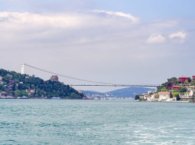 Avrupa ve Asya 'yı birbirine bağlayan Boğaz Köprüsü' nün kıyı binaları ve mavi sularla manzarası