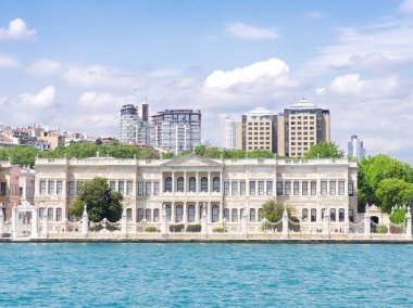 İstanbul, Türkiye 'deki Dolmabahce Boğazı' ndaki modern binaların arka planında Dolmabahce Sarayı