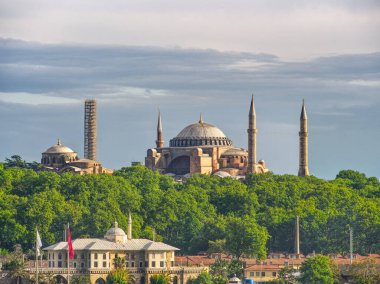 İstanbul, Türkiye 'de yeşil ağaçların üzerinde yükselen kubbeleri ve minareleri ile İkoniç Ayasofya Camii