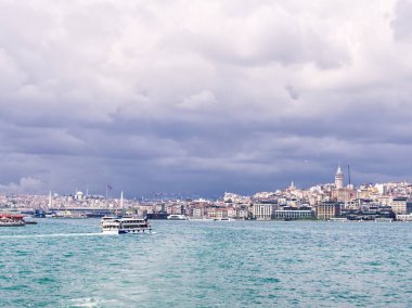 İstanbul şehir manzarası Boğaz 'daki teknelerle bulutlu gökyüzünün altında