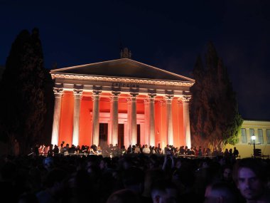 Atina, Yunanistan - 3 Mayıs 2025: Zappeion gece kırmızıyla aydınlatıldı, Atina Şehir Festivali 2025 'te bir kalabalık toplandı