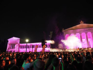Atina, Yunanistan - 3 Mayıs 2025: Zappeion 'da düzenlenen açık hava konserine katılan kalabalık, Atina Şehir Festivali 2025 sırasında mor ışıklarla aydınlandı