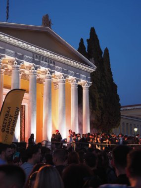 Atina, Yunanistan - 3 Mayıs 2025: Atina Şehir Festivali sırasında alacakaranlık gökyüzüne karşı kalabalık ve ağaçlarla aydınlanmış Zappeion sütunları