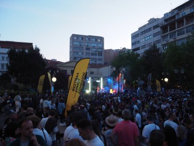 Atina, Yunanistan - 4 Mayıs 2025: Aydınlatılmış sahne ve arka plandaki binalarla birlikte kalabalık Atina Şehir Festivali 2025 'te açık hava konseri için toplandı