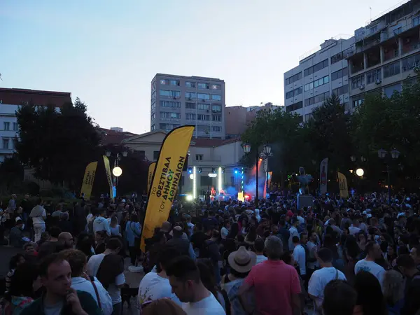 Atina, Yunanistan - 4 Mayıs 2025: Aydınlatılmış sahne ve arka plandaki binalarla birlikte kalabalık Atina Şehir Festivali 2025 'te açık hava konseri için toplandı