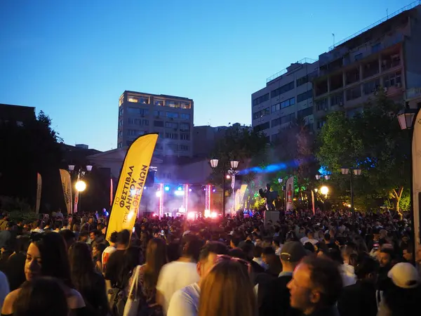 Atina, Yunanistan - 4 Mayıs 2025: 2025 Atina Festivali 'nde renkli ışıklar ve kentsel binaların yer aldığı açık hava müzik festivalinin keyfini çıkaran büyük bir kalabalık