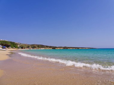 Mavi gökyüzünün altında kristal berrak turkuaz suyu ve altın kumu olan el değmemiş bir sahil manzarası. Koufonisia Adaları, Kiklad Adaları, Yunanistan