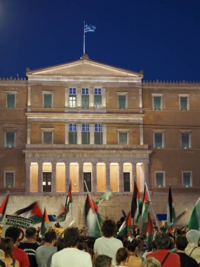 Atina, Yunanistan - 10 Ağustos 2025: İnsanlar mavi gökyüzüne karşı sütunları olan Yunan parlamento binasının önünde toplandı