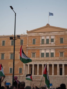 Atina, Yunanistan - 10 Ağustos 2025: Büyük olasılıkla bir gösteri sırasında büyük bir resmi binanın önünde Filistin bayrakları sallayan kalabalık