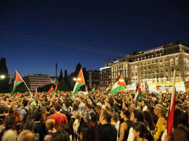 Atina, Yunanistan - 10 Ağustos 2025: Kalabalığın aydınlık binalarla kentsel alanda Filistin bayrakları salladığı büyük gece gösterisi