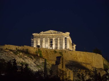 Akropolis tepesindeki Antik Yunan Partenon tapınağı, karanlık gece gökyüzüne karşı, iskele ile aydınlandı