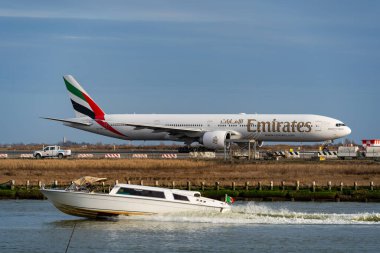 Emirates aicraft at Marco Polo Airport with cruising water taxi in the foreground. High quality photo