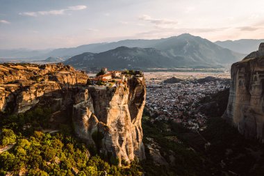 Günbatımında Meteora vadisi ve tarihi kanyonu, Kalambaka, Yunanistan, gölgeler, çarpık yol, köprü ve dağların nefes kesen manzarası.