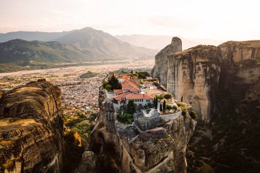 Günbatımında Meteora vadisi ve tarihi kanyonu, Kalambaka, Yunanistan, gölgeler, çarpık yol, köprü ve dağların nefes kesen manzarası.